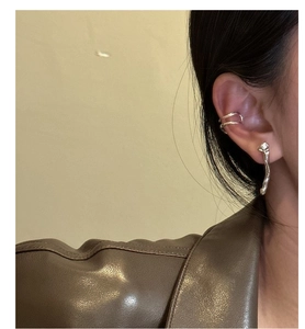 Detail of silver S925 liquid metal style earrings and double layer ear cuff on model