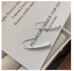Detailed macro view of minimalist S925 sterling silver drop earrings with a brushed matte finish