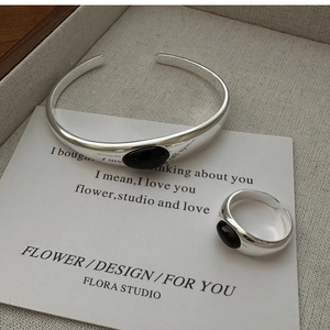 Macro detail of S925 sterling silver ring and bangle set with oval black onyx gemstone