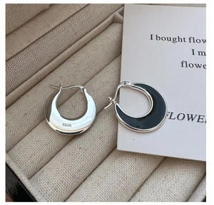 Detail of S925 sterling silver hoop earrings with black enamel inlay on jewelry velvet