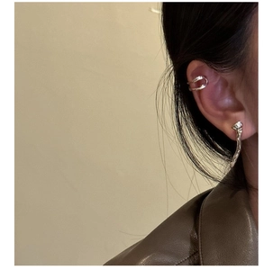 Detailed view of silver double-layered ear cuff and lava texture stud on a female model