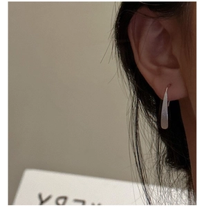 Detail of matte silver teardrop earrings on model showing minimalist S925 sterling style