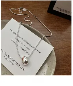 Detail of S925 sterling silver hammered teardrop pendant with stylish bead chain