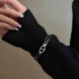 Bracelet jonc minimaliste en argent S925 avec maillon émaillé noir sur une manche en tricot