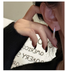 Close-up of minimalist S925 sterling silver drop earrings with a brushed matte finish