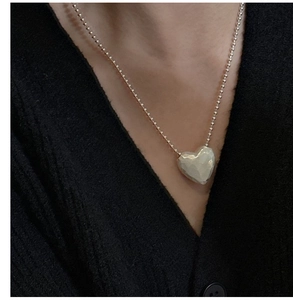 Detail of silver heart necklace with hammered texture on minimalist ball chain necklace