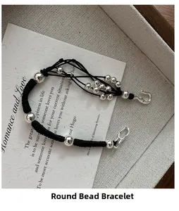 Detailed view of handmade black braided rope bracelet with polished silver beads and hook