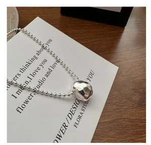 Close-up of S925 sterling silver bead chain with irregular liquid metal drop pendant