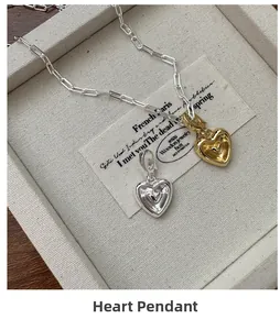 Vue détaillée des pendentifs cœur en or et argent dans un écrin à bijoux de luxe