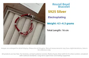 Detail of S925 sterling silver beads on a handcrafted red woven bracelet with a dragon clasp