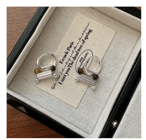 Detail of S925 silver hoop earrings with vintage brown stone and textured metal drop