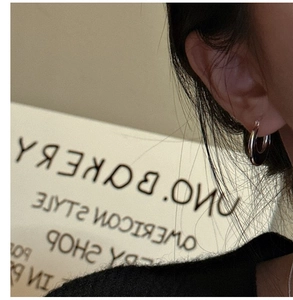 Close-up of minimalist S925 sterling silver hoop earrings worn on a model's ear