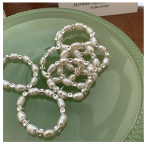 Macro shot of S925 silver square bead pearl rings on a decorative glass tray
