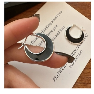 Detail of S925 sterling silver crescent hoop earrings with black enamel drip finish