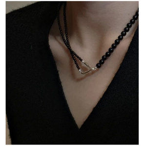 Detail of s925 silver necklace featuring black beads and an organic silver clasp on neck