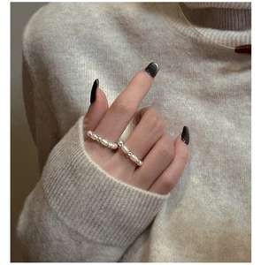 Detailed view of elastic handmade freshwater pearl ring with silver beads on a model's hand