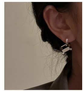 Close-up of S925 sterling silver geometric earrings with metal cylinders and dark beads