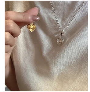 Gros plan du collier avec pendentif cœur en argent 925 en finitions or et argent