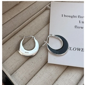 Macro view of S925 sterling silver hoop earrings with black enamel and hallmark