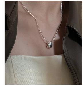 Detail view of S925 sterling silver hammered teardrop necklace on model's neck