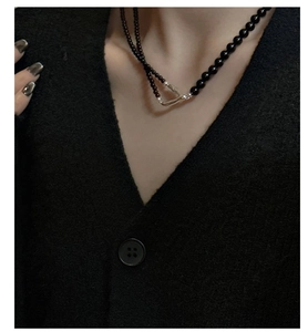 Detail of s925 silver double-layered beaded necklace featuring a metallic Y-shape accent