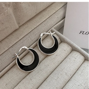 Macro shot of S925 sterling silver crescent earrings with black enamel inlay in a jewelry box