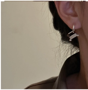 Detail of S925 sterling silver geometric earring with cylindrical and spherical charms