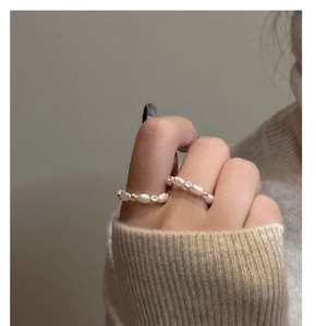 Close-up of S925 silver cube pearl rings worn with a warm beige knit sweater