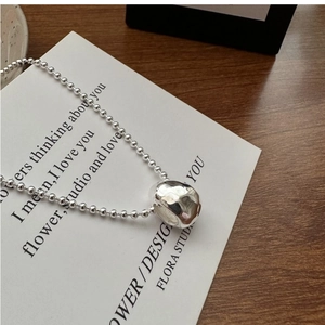 Close-up of S925 silver beaded chain with textured liquid metal drop pendant