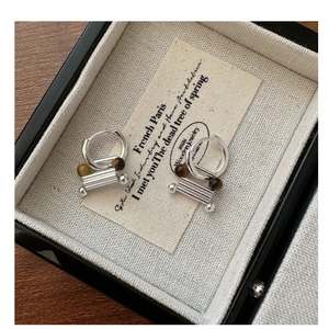 Detail view of S925 sterling silver hoop earrings with tiger eye stone and metallic tubes