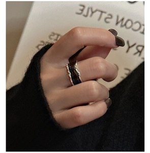 Macro shot of S925 silver wide ring with black glaze and irregular textured surface