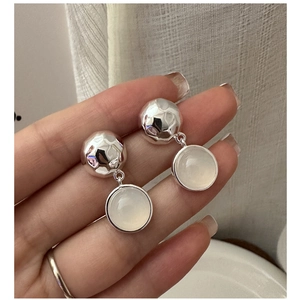 Vue détaillée de boucles d'oreilles en argent S925 avec bille martelée et agate blanche