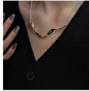 Minimalist S925 silver wave pendant necklace shown on a black knit sweater