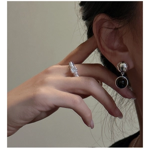 Gros plan de boucles d'oreilles S925 en argent avec disque noir et bague minimaliste