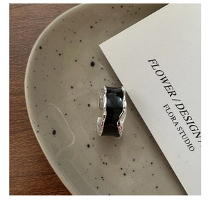 Detail of S925 sterling silver ring with black enamel and irregular textured silver edges