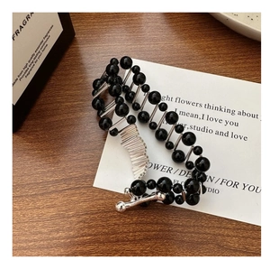 Close-up of S925 silver bracelet featuring black agate beads on a decorative card