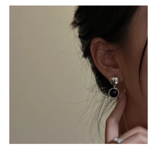 Vue détaillée des boucles d'oreilles en argent avec fini martelé et agate noire