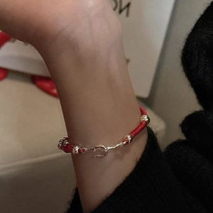 Handcrafted S925 sterling silver beads and red woven cord bracelet on a wrist