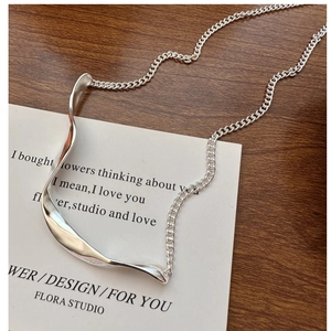 Detailed view of S925 sterling silver wavy pendant on a refined curb chain necklace