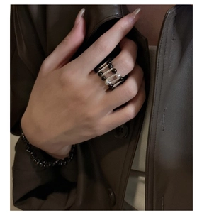 Macro detail of industrial silver-toned bar ring with black beads on a model