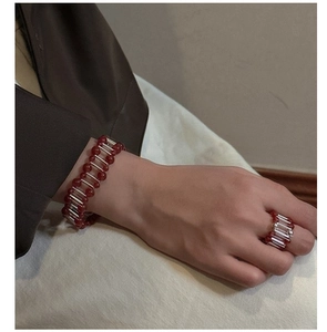 Detailed shot of red agate beaded bracelet and matching ring on model wrist