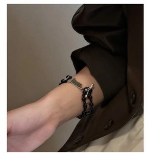 Detail of double-layer black agate bead bracelet with silver industrial hardware on wrist