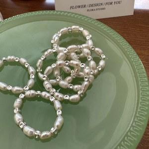 S925 silver ring featuring baroque pearls and square beads on a vintage ceramic plate