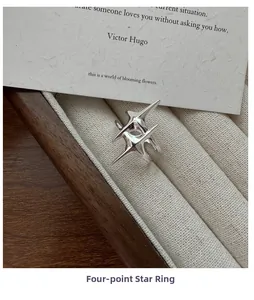 Vue détaillée d'une bague étoile à quatre branches en argent dans une boîte à bijoux
