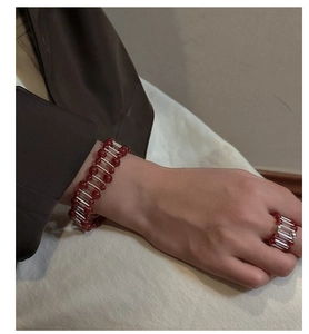 Detail of S925 silver beaded bracelet and ring set with deep red agate beads on wrist