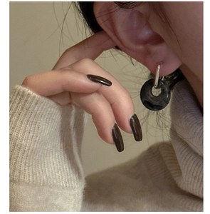 Close-up of S925 silver hoop earrings with a black natural stone doughnut-shaped pendant