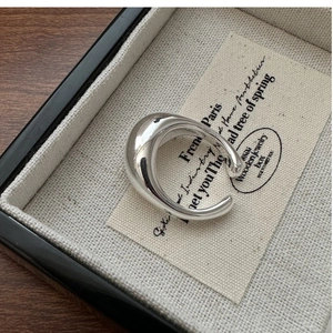 Macro shot of minimalist wide C-shaped polished silver ring in a premium jewelry box
