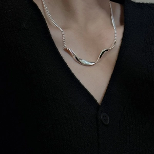 Minimalist S925 sterling silver necklace with unique wave-shaped pendant on woman's neck