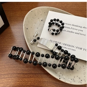 Detail view of S925 silver bracelet and ring set with black onyx beads on ceramic tray