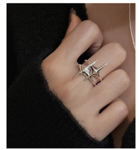 Détail d'une bague étoile minimaliste en argent S925 avec design poli de croix et d'épines